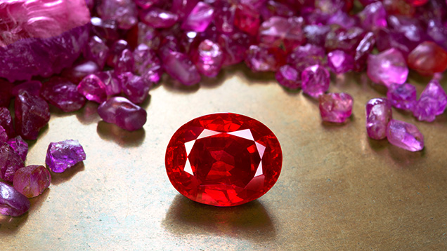 Figure 1. A faceted heated ruby from Mogok, Myanmar, weighing more than 3 ct, stands out against a backdrop of untreated ruby rough from the same origin. The striking appearance of Mogok ruby is highly sought after. Photo by Wimon Manorotkul; faceted ruby courtesy of Kiarttichatra Intarungsee. Figure 1. A faceted heated ruby from Mogok, Myanmar, weighing more than 3 ct, stands out against a backdrop of untreated ruby rough from the same origin. The striking appearance of Mogok ruby is highly sought after. Photo by Wimon Manorotkul; faceted ruby courtesy of Kiarttichatra Intarungsee.
