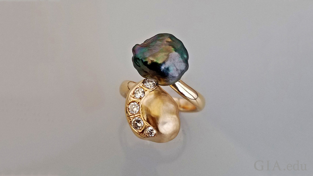 A black Tahitian pearl and a gold nugget in the shape of a Keshi pearl (with 5 diamonds set in it) bypass one another in this ring. A black Tahitian pearl and a gold nugget in the shape of a Keshi pearl (with 5 diamonds set in it) bypass one another in this ring.