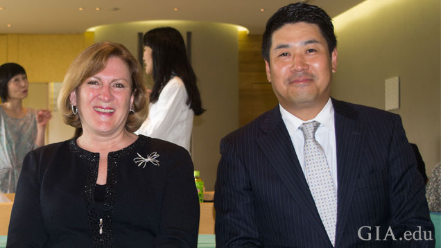 Susan Jacques(苏珊·雅克)和穿着职业装的 Ken Fujita(藤田健)在一个活动中并排坐在一起。 Susan Jacques(苏珊·雅克)和穿着职业装的 Ken Fujita(藤田健)在一个活动中并排坐在一起。