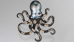 The octopus head is a baroque Tahitian cultured pearl and its arms are made of black, yellow and white diamond (in a striped pattern) set in black-plated 18K gold.