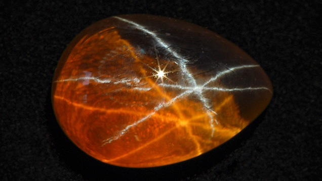 Brownish yellow synthetic sapphire with white star and brownish yellow star