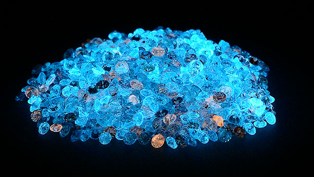 Many loose laboratory-grown diamonds glowing under short-wave uv light Many loose laboratory-grown diamonds glowing under short-wave uv light